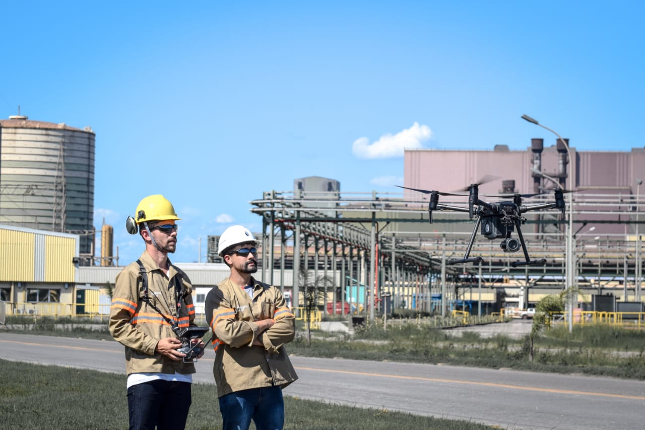 Foto da matéria arquitetura com drones - Dois pilotos observam um drone em funcionamento